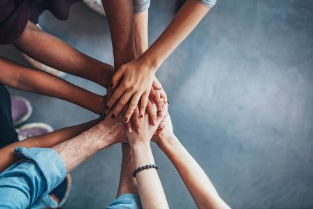 People's hands stacked on top of each other in a circle