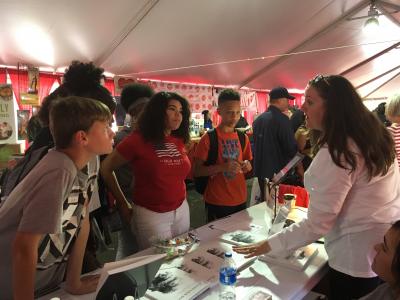 Team members discuss the Second Look Book with festival attendees