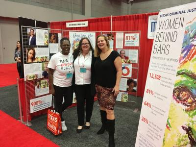 Women's justice campaign representatives in front of posters showcasing the campaign's work