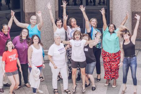 Women jumping joyfully together at the Texas Capitol