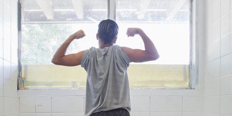 Incarcerated teen in strong pose in front of window