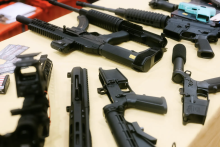 Semi-automatic weapons are laid on a table at a gun show in San Marcos in January. Credit: Jordan Vonderhaar for The Texas Tribune
